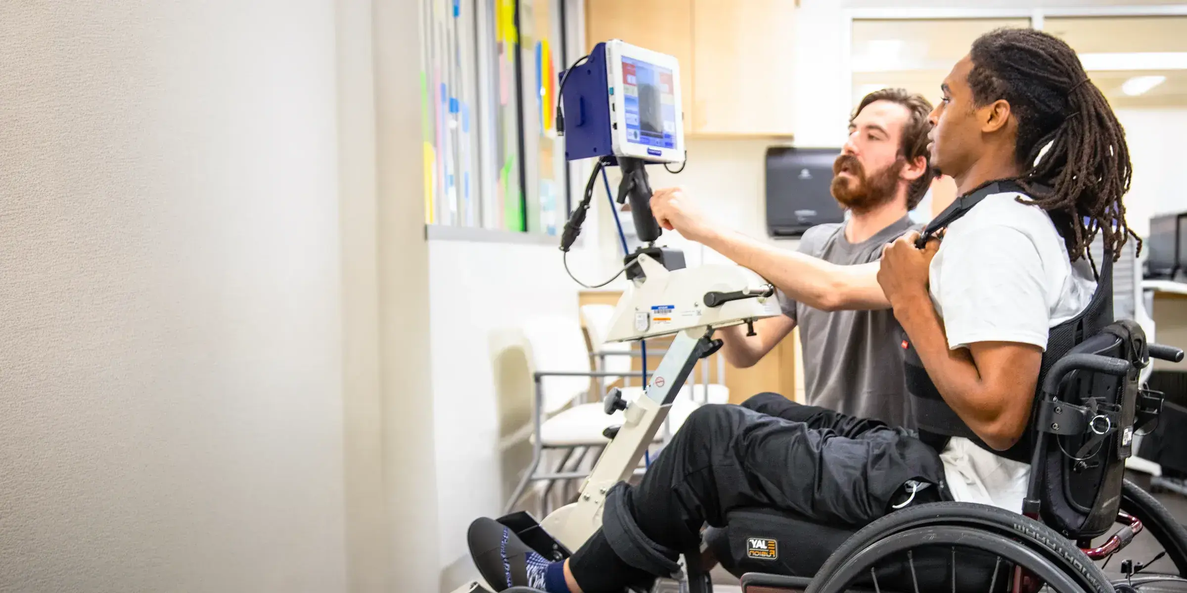 therapist instructs patient in wheelchair
