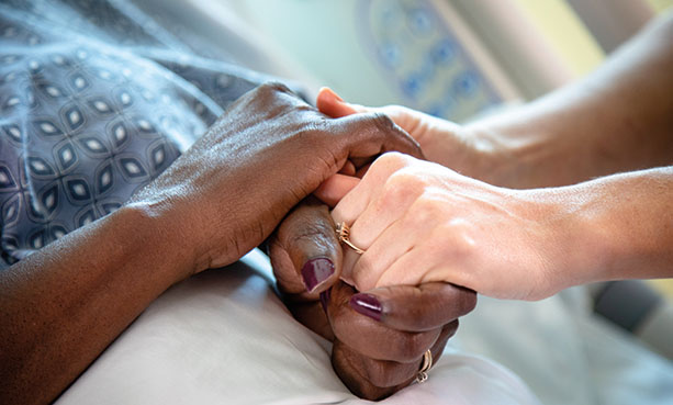 close up of nurse holding patient's hands