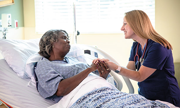 nurse holding patient's hand